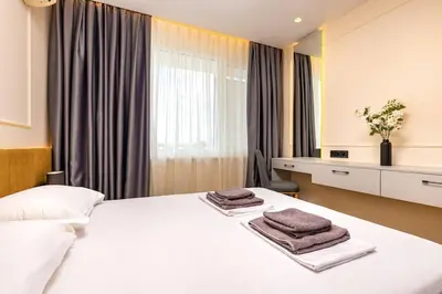 a bedroom with a white bed with towels on it at Sunset 2BR Apartment Central Street PARKING Included in Plovdiv