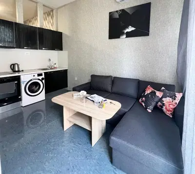 a living room with a blue couch and a table at Flower house 6 in Sofia