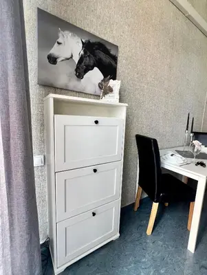 a white dresser with a desk and a picture of horses at Flower house 6 in Sofia