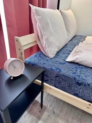 a bed with pillows and a table with a fan at The rainbow 9 in Sofia