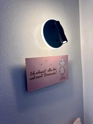 a light on a wall with a sign on it at The rainbow 9 in Sofia