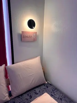 a corner of a room with a bed and a light at The rainbow 9 in Sofia