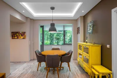 a dining room with a table and chairs and a yellow cabinet at Elegant Escape in The Heart of The City by Flat Mаnager in Sofia