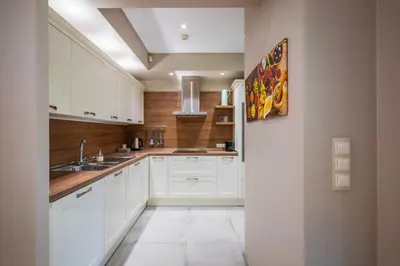 a kitchen with white cabinets and a sink at Elegant Escape in The Heart of The City by Flat Mаnager in Sofia