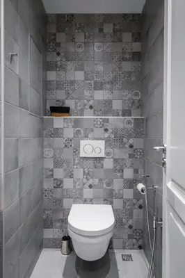 a bathroom with a toilet and a tiled wall at Elegant Escape in The Heart of The City by Flat Mаnager in Sofia