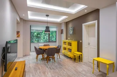 a dining room with a table and chairs and a yellow cabinet at Elegant Escape in The Heart of The City by Flat Mаnager in Sofia