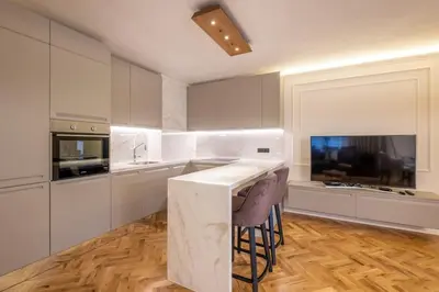 a kitchen with white cabinets and a bar with stools at SOFapart Stylish & Fancy Place with 1 BDR in Sofia