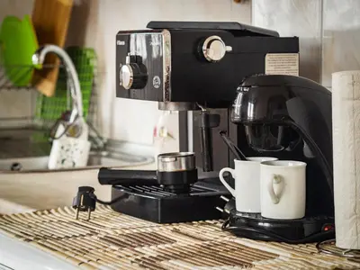 a coffee maker and two coffee cups on a counter at Стаи за гости Божана in Razlog