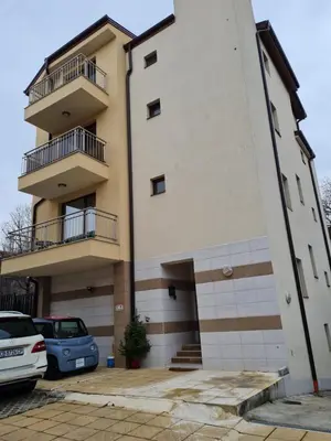a building with cars parked in front of it at Cozy studio with balcony in Sofia