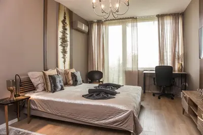 a bedroom with a bed and a chandelier at Rome Stylish apt w Working Space and Paid Parking Spot in Sofia