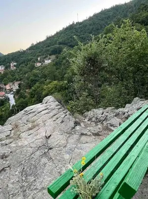 a green bench sitting on top of a mountain at Rodopi Mountain Village House in Narechen