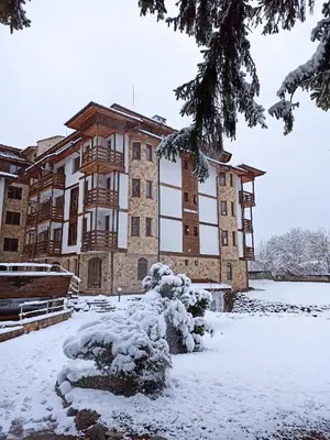 a large building with snow on the ground at Роси Студио Банско in Bansko