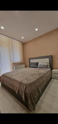 a bedroom with a large bed in a room at Апартамент Недялкови II in Sandanski