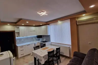 a kitchen with a table and chairs in a room at Апартамент Недялкови II in Sandanski