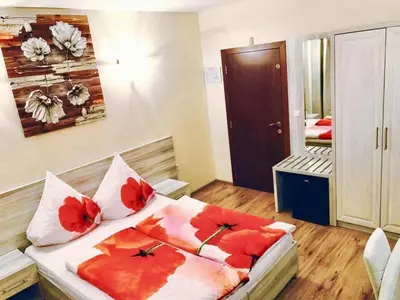 a bedroom with a bed with red flowers on it at D Villa in Mineralni Bani