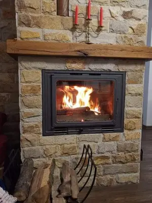 a fireplace with two red candles on top of it at Sokol i Kalina spa in Pchelin