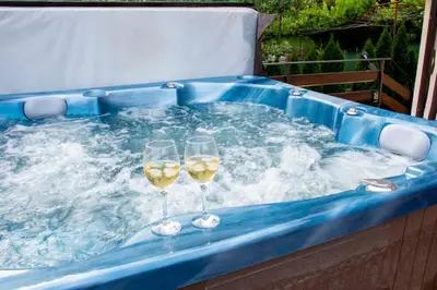 two glasses of wine in a hot tub with water at Kalina i Sokol spa in Pchelin