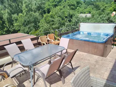 a patio with a table and chairs and a hot tub at Kalina i Sokol spa in Pchelin