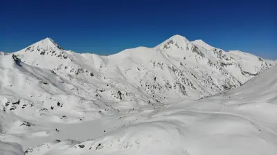 a mountain covered in snow with a blue sky at GT Aspen House Apartments in Bansko