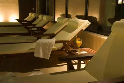 a row of chairs and a table with a glass of wine at GT Aspen House Apartments in Bansko