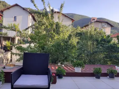 a chair sitting on a patio with potted plants at Easy rooms in Sapareva Banya