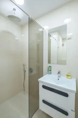 a white bathroom with a sink and a shower at Top Location, Brand New 3 BDRM Apt & Free parking in Sofia