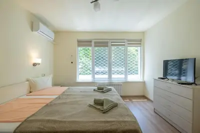 a bedroom with a large bed with a flat screen tv at Top Location, Brand New 3 BDRM Apt & Free parking in Sofia