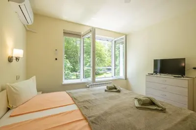 a bedroom with a bed with a tv and a window at Top Location, Brand New 3 BDRM Apt & Free parking in Sofia