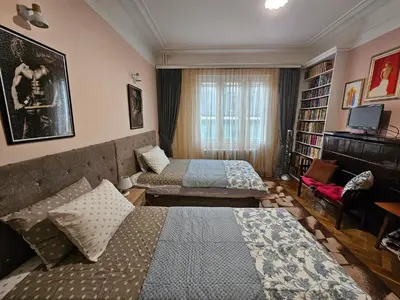 a hotel room with two beds and a book shelf at Alex Place-Central Sofia in Sofia