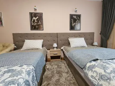 a bedroom with two beds and a table with lamps at Alex Place-Central Sofia in Sofia