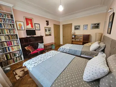 a bedroom with two beds and a desk and a tv at Alex Place-Central Sofia in Sofia