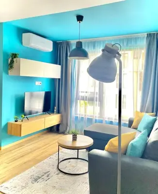 a blue living room with a couch and a table at Luxurious apartment 1BDR by Top Kvartiri Ltd in Sofia