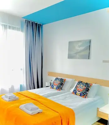 a bedroom with a large bed with an orange blanket at Luxurious apartment 1BDR by Top Kvartiri Ltd in Sofia