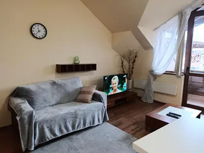 a living room with a couch and a tv at Cozy flat in NEON in Bansko