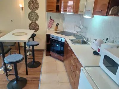 a kitchen with a sink and a stove and a table at Cozy flat in NEON in Bansko