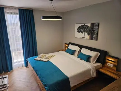 a bedroom with a large bed with blue curtains at Apartmenthaus Oborishte - 31 in Panagyurishte