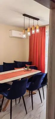 a dining room with a table and blue chairs at Apartmenthaus Oborishte - 31 in Panagyurishte