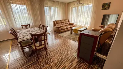 a living room with a table and a couch at Villa Orpheus in Chepelare
