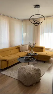 a living room with a yellow couch and a table at Славянска резиденс - Спокойствие в центъра на Пловдив in Plovdiv