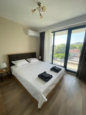 a bedroom with a bed with two towels on it at Modern 1BR Apart FREE Parking with Hill View in Plovdiv
