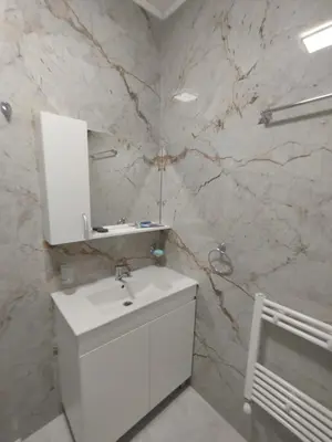 a white bathroom with a sink and a mirror at Stylish apartment Zingara 2 in Sofia