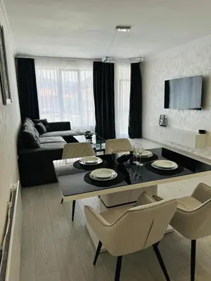 a living room with a table with chairs and a couch at Danielis Apartament in Velingrad