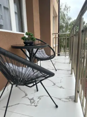 a patio with a table and chairs on a balcony at Danielis Apartament in Velingrad