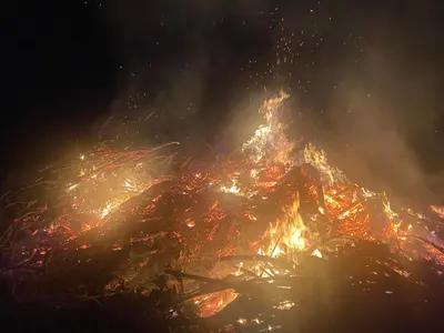 a large bonfire with smoke and flames at night at Къща за гости ЕВА in Madzhare