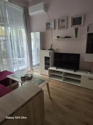 a living room with a tv and a table at Roses in Sofia