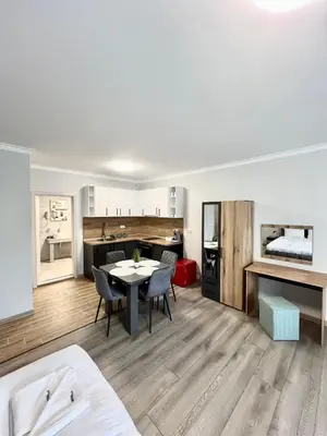 a living room with a table and chairs and a kitchen at GREEN PARK Apartments and rooms for guests in Asenovgrad