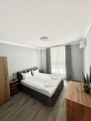 a bedroom with a large bed and a large window at GREEN PARK Apartments and rooms for guests in Asenovgrad