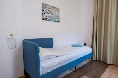 a blue bed in a room with a curtain at Kostenets Hills in Kostenets Village