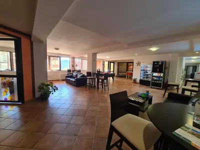 a living room with a couch and tables and chairs at Saphir apartment , Rhodopi Pearl Pamporovo in Pamporovo