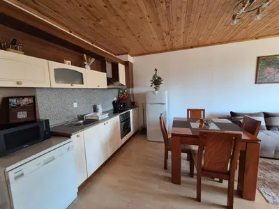 a kitchen and dining room with a table and a couch at Saphir apartment , Rhodopi Pearl Pamporovo in Pamporovo